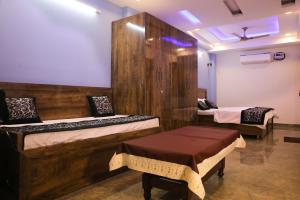 新德里CASA CENTRAL的一间设有两张床的房间,内设一张长凳