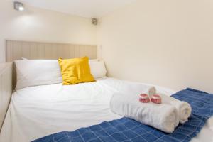 爱丁堡ALTIDO Haymarket的一张带黄色枕头的白色床和2条毛巾