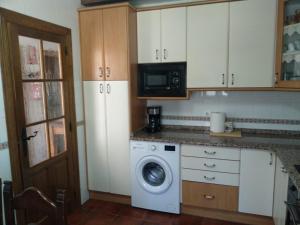 CaleruegaLa Casa Del Venancio的厨房配有洗衣机和微波炉。