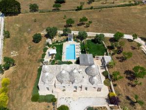 奥斯图尼Trulli Gianpaolo - Luxury Villa的享有带游泳池的建筑的空中景致
