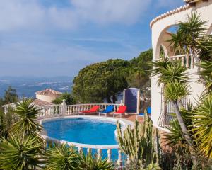 库姆布勒德尔索尔Casa Inca, Villa with heatable pool and top view atop Moraira El Portet的一座别墅,设有游泳池和棕榈树