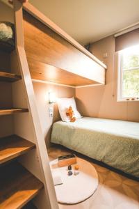 鲁瓦扬Camping Le Royan的小房间设有两张双层床和一张桌子