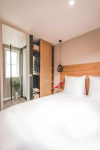 鲁瓦扬Camping Le Royan的卧室配有白色的床和镜子
