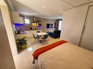 德班ARCHITECTS VIEW - VIP FAMILY SUITE的一间卧室配有一张床、一间厨房和一张桌子
