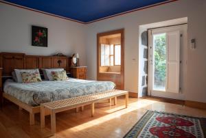 Castelo Branco昆塔梅亚埃拉农庄的一间卧室配有一张床和长凳
