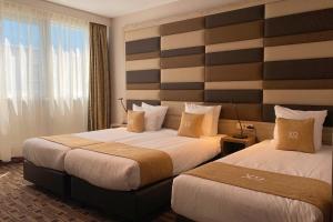 阿姆斯特丹XO蓝色广场酒店的酒店客房设有两张床和大窗户。