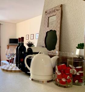 伊索拉察Cima de’ Piazzi Apartment的台面配有茶壶和葡萄酒瓶
