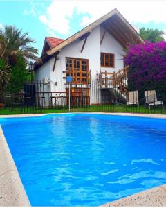 门多萨Tanino Guest House的房子前面的房子和游泳池
