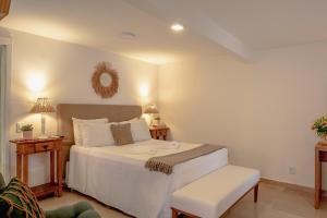 布希奥斯Pousada Blanca Mar的卧室配有白色的床和椅子