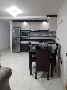 HuancavelicaPYMABET的厨房配有桌椅和冰箱。
