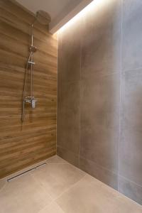 帕尔加Alboro seaside suites的带淋浴的浴室(带木墙)