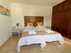 塞博河畔卡莱塔CALIMA Holiday House的一间卧室配有一张大床和两条毛巾