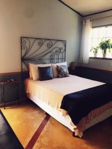 伊利亚贝拉Pousada Canto Bella Terra的一间卧室设有一张大床和一个窗户。