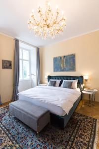 维也纳Parkview Boutique Apartments的一间卧室配有一张大床和一个吊灯。