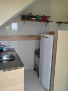 卡博迪圣阿戈斯蒂尼奥Kitnet 2,vista fantastica的一间带水槽和冰箱的小厨房