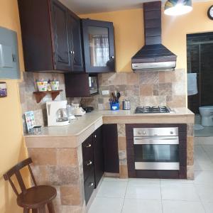 瓜亚基尔Blanca Apartments的厨房配有棕色橱柜和炉灶烤箱