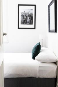 悉尼温亚德酒店的一张白色的床,里面配有绿色枕头