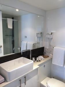 悉尼The Social Hotel, Sydney的白色的浴室设有水槽和镜子