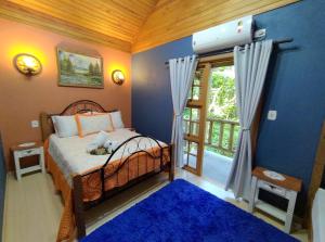 格拉玛多Cabana Drechsler Gramado的一间卧室设有一张床和一个大窗户
