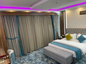 艾卜哈Mabeet Residances的酒店客房设有一张大床和紫色灯