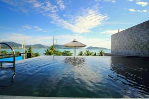 芭东海滩See Sea Villa Phuket SHA的一个带遮阳伞和水的游泳池