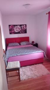 VrlikaHoliday home Marija的一间卧室配有一张带粉红色床头板的大床