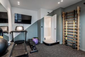 雅典Athinaion Recreation Suites的一间设有跑步机和门的健身房的客房