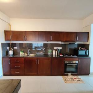 科伦坡Modern apartment in close proximity to the Beach的厨房配有木制橱柜、水槽和炉灶。
