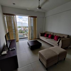 科伦坡Modern apartment in close proximity to the Beach的客厅配有沙发和桌子
