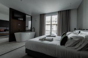 雅典Athinaion Recreation Suites的一间卧室设有一张大床和一个浴缸