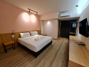 曼谷The Neuf@Ratchada的配有一张床和一台平面电视的酒店客房