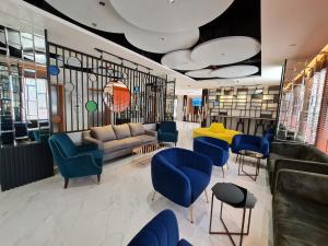 曼谷The Neuf@Ratchada的一间等待室,配有蓝色的椅子和沙发