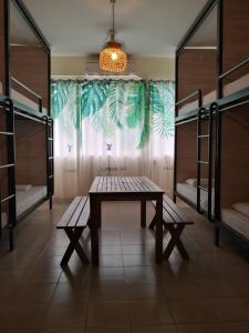 哥打京那巴鲁神山青年旅社的客房设有桌子、长凳和双层床。