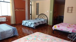 万查科Casa Familiar Eventos y Recepciones Huanchaco Huanchaquito的一间房间,有三张床