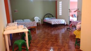 万查科Casa Familiar Eventos y Recepciones Huanchaco Huanchaquito的一间设有两张床和一张桌子及椅子的房间