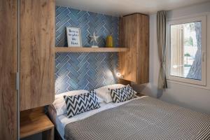 扎达尔Falkensteiner Premium Mobile Homes and Camping Zadar的一间卧室配有一张蓝色墙壁的床