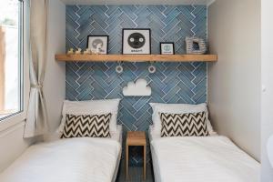 扎达尔Falkensteiner Premium Mobile Homes and Camping Zadar的小型客房的两张床,设有墙壁