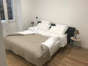 尼斯Sea View Nice Port Appartment的一张带白色床单和枕头的床