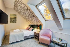 克雷尼察Hotel Willa Tatrzańska的一间卧室设有一张床、一个窗口和一把椅子