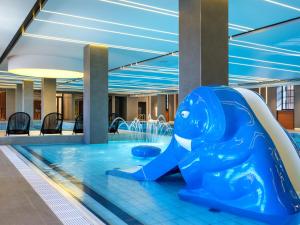 克拉科夫Mercure Krakow Fabryczna City的蓝色海豚在一座建筑物的游泳池里