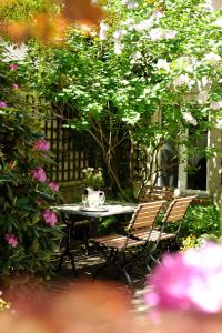 慕尼黑Boutique Hotel Splendid的花园里种满鲜花,配有桌椅
