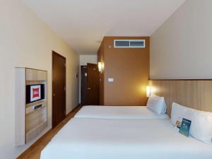 迪拜阿尔巴沙宜必思酒店的卧室配有一张白色大床和电视。