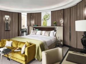 美因河畔法兰克福法兰克福歌剧院索菲特酒店的一间卧室配有一张大床和一张黄色的沙发
