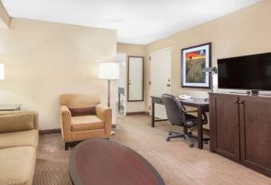 雷德迪尔红鹿市贝蒙特套房酒店的酒店客房配有桌椅和电视。