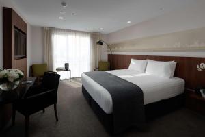 基督城基督城雷吉斯拉蒂默酒店的酒店客房设有一张大床和一张书桌。