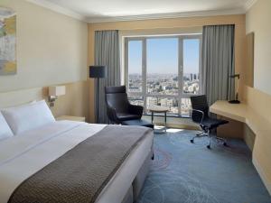安曼Mövenpick Hotel Amman的酒店客房设有一张床和一个大窗户