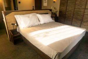 Albosaggia泰拉德尔索勒农庄旅馆的一张配有白色床单和枕头的大床