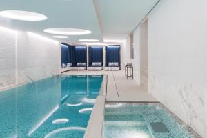 日内瓦The Woodward - an Oetker Collection Hotel的蓝色水的酒店客房的游泳池