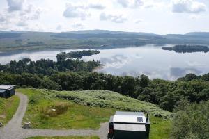 Loch AweOdhrán Lodge, St Conan's Escape: Home with a view的停泊在湖边小山上的 ⁇ 