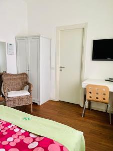 米兰Via Padova 165的客房设有床、书桌和电视。